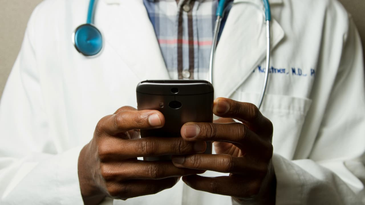 A doctor is using a phone