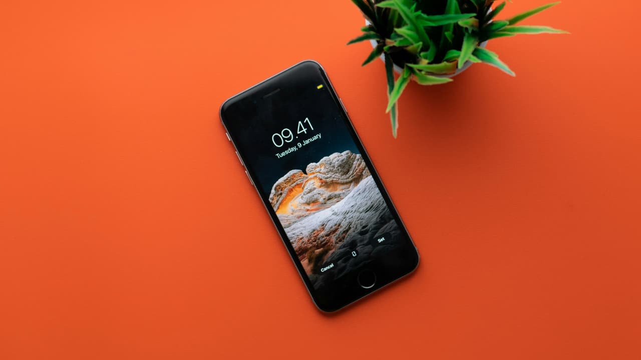 An iPhone kept on an orange surface