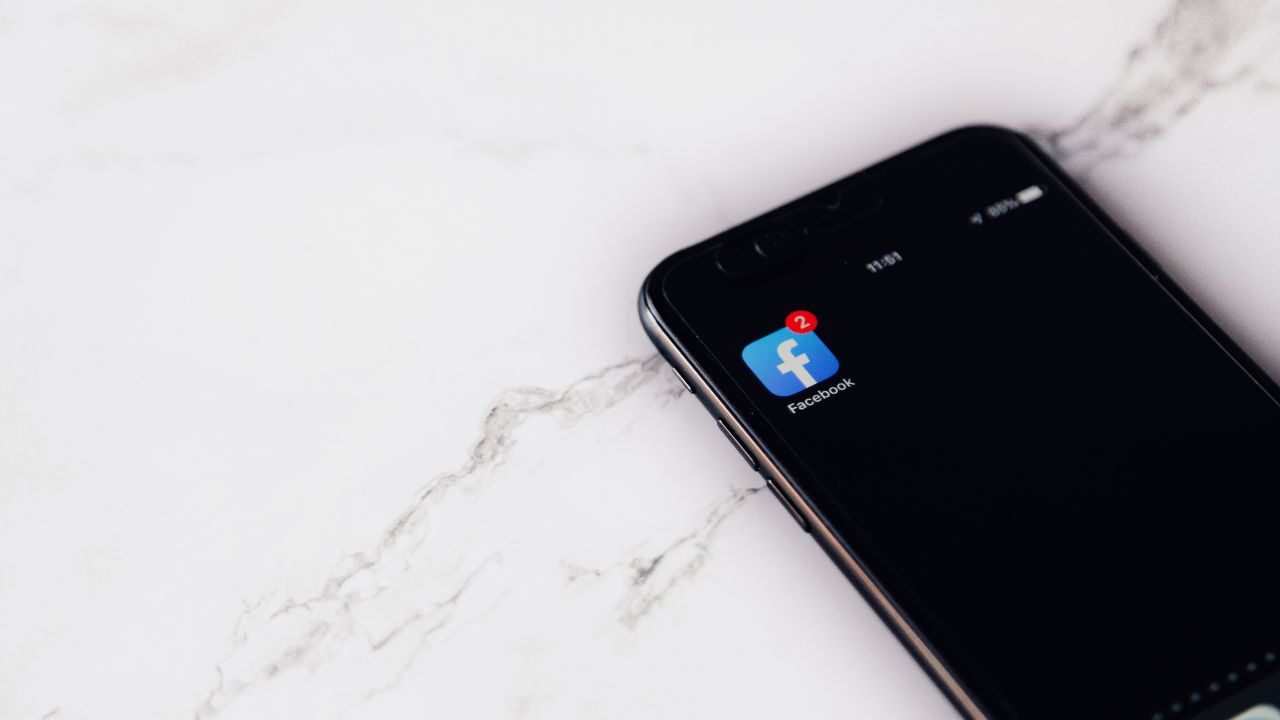 Smartphone displaying Facebook app icon with two notifications