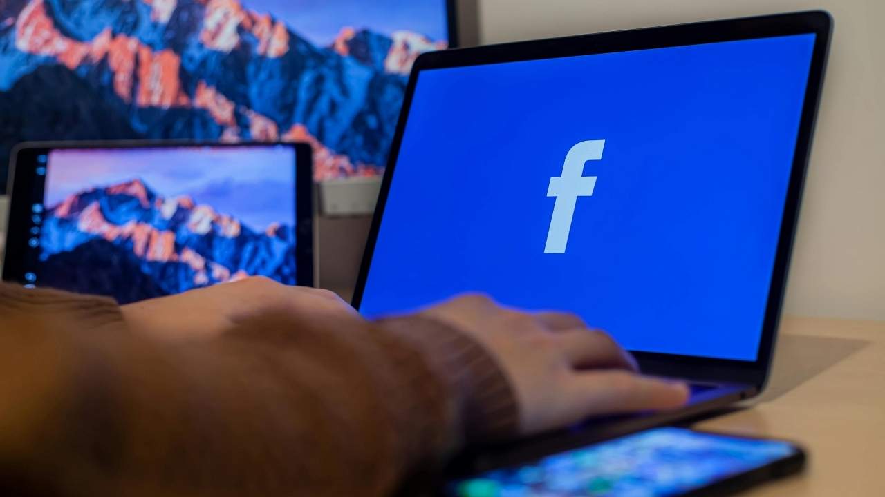 A laptop with the Facebook logo on the screen