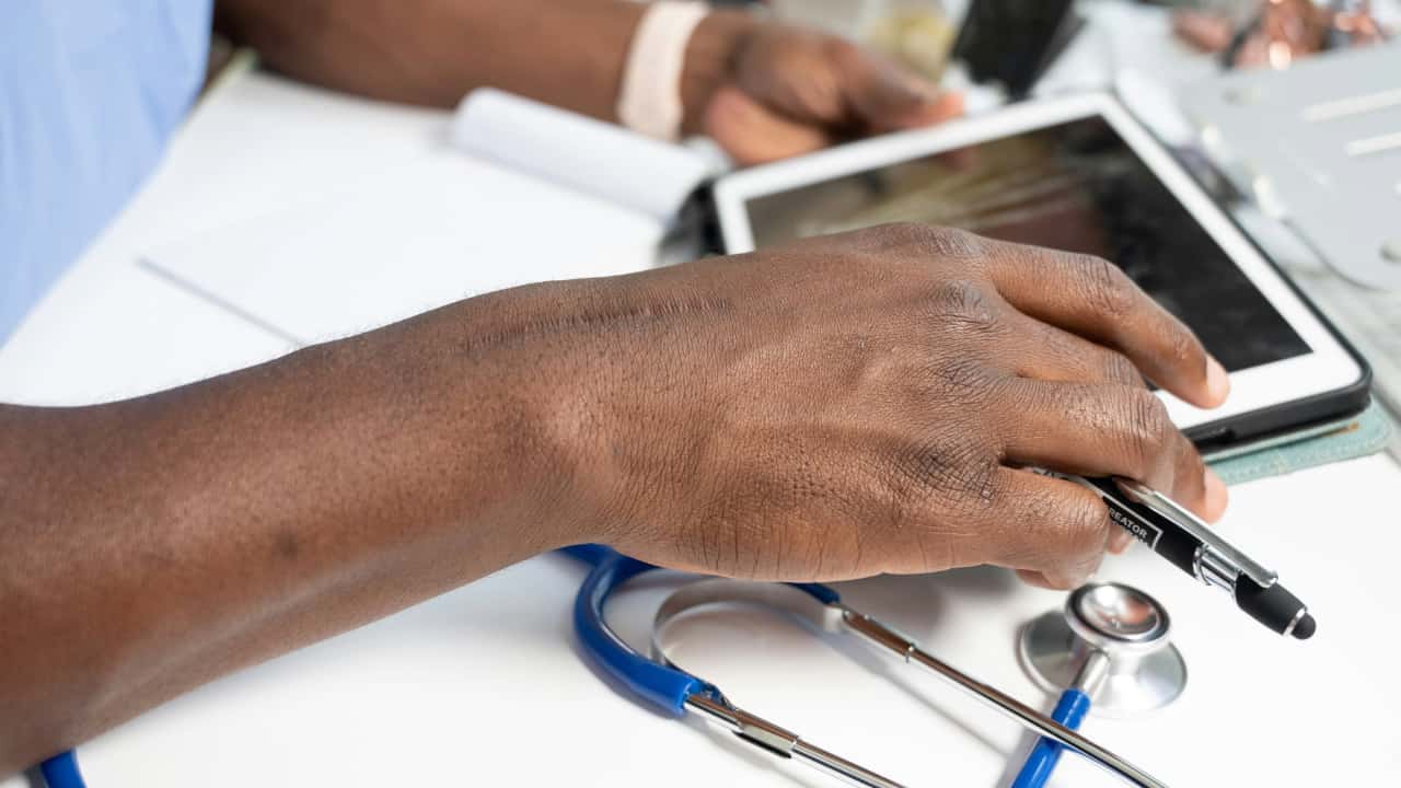 A healthcare professional using a tablet
