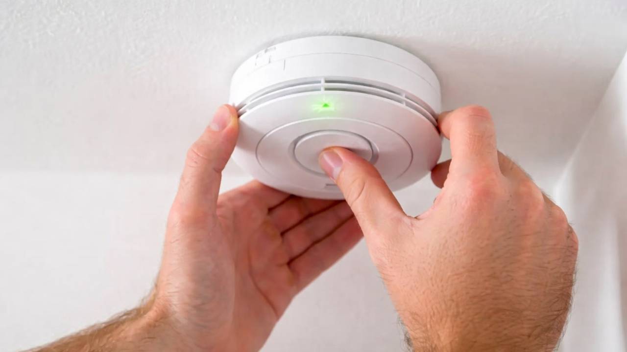 A man installing a fire detector